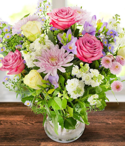 Aintree - A beautiful collection of the prettiest lilac roses, bloom chrysanthemums, scented white stock, long-lasting lilac freesia, white roses all complemented by luxurious seasonal foliages.