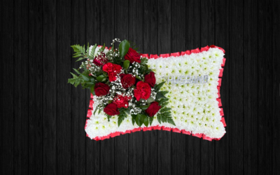 Red Diamond - PIL65 - Beautifully arranged Pillow tribute in red and white colours using roses, carnations, gypsophilia, leather leaf on white chrysanthemums base and red ribbon edge. Silver lettering is additional 70p per letter.