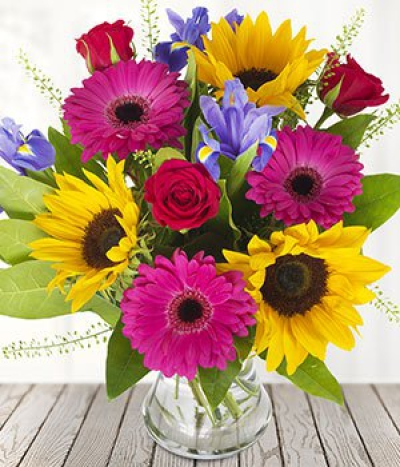 Summer Season - Invite the summer into your home. This summer mix is a selection of sunshine filled Sunflowers, crisp roses with the always popular pink gerberas. With a dash of iris and the bouquet is summer ready.