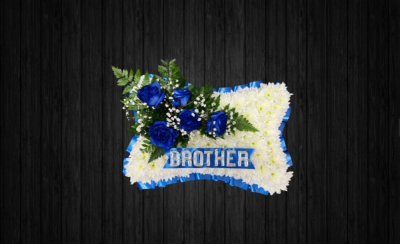 Soft Touch - PIL57 - Blue and white pillow tribute using roses, gypsophilia, leather leaf on a white chrysanthemums base with ribbon edge. Silver lettering is additional 70p per letter.
