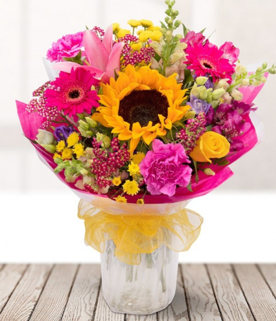 Summer Loving - Our Summer Loving hand tied bouquet contains a stunning mix of beautiful yellow, pink and purple blooms. A statement sunflower is surrounded by roses, germini, carnations, lilies, alstros, and lisianthus.