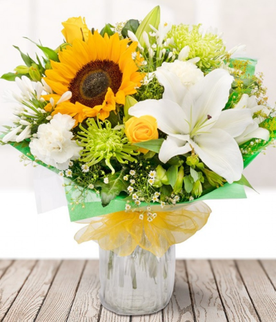 Joy - Send some Joy with a beautiful mix of yellow sunflowers, roses, and alstros, white carnations, and lilies with seasonal foliage.
