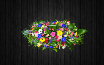 Chameleon - CSK90 - Vibrant coloured Coffin spray using roses, germini, lisianthus, spray carnations, statice, limonium, aspadistra, leather and palm leaves. Price: 3ft Standard - 4ft Deluxe - 5ft Luxury