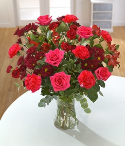 Firecracker - Cerise pink Roses with burgundy Chrysanthemums and bright Alstroemeria for a hot and spicy bouquet. Hand-Tie in water.