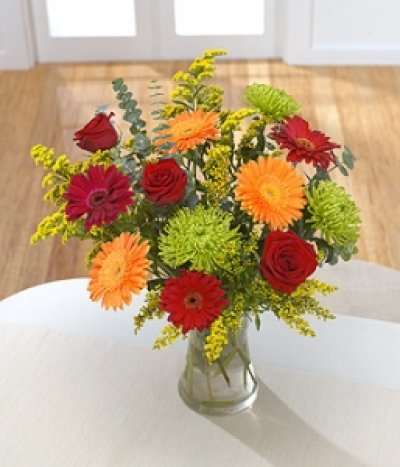 Citrus Zing - Glowing orange and red Gerbera and red Roses create a warm arrangement to brighten somebody's day. Hand-Tie in water.