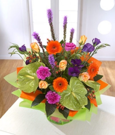Harlequin Delight - A vase full of colour - lime Anthurium, orange Gerbera and the ever popular Rose are mixed with purple Lisianthus and Liatris.
