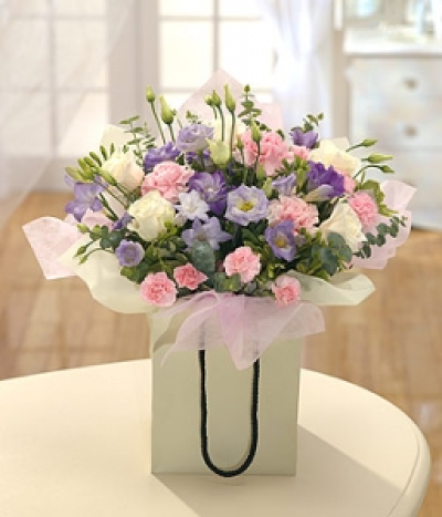 Angel's Delight - A beautiful selection of pink, cream and lavender Roses, Freesias and Carnations beautifully presented in a gift bag.
