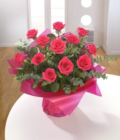 Pinky Cutie - The perfect gift - a dozen cerise Roses and Eucalyptus presented as an aqua pack hand-tied.