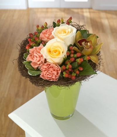 Sahara - Colour and texture are the name of the game for this vase arrangement. A natural twig collar contains treats of Roses, Cymbidium Orchids, apricot Carnations and Hypericum berries.