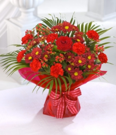 Red Hot - Red hot Roses, Carnations and berries in a hand-tied bouquet.