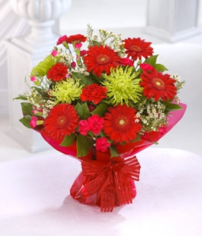 Scarlet Zest - The red flowers illuminate the zesty green bloom Chrysanthemums whilst Gerberas are the stars in this rich hand-tied.  Send this to warm up someone's day.
