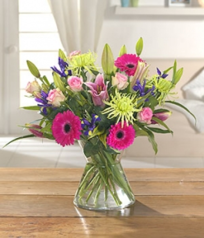 Diamond Brilliance - This vibrant arrangement will bring a bright burst of fragrance to anyones home: Jewel Roses, Serena Gerbera and Lily Cobra. Hand-Tie in water.