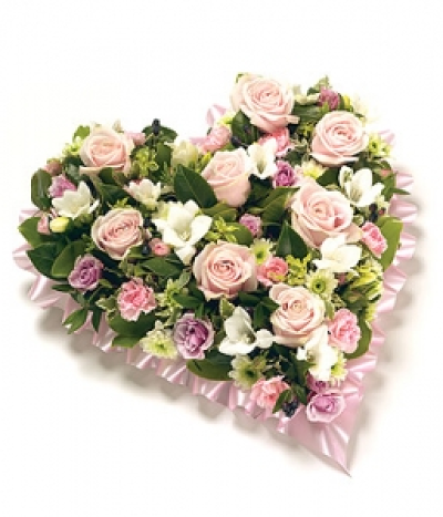 Loose Floral Heart - A beautiful pink & white coloured heart shaped tribute, featuring Roses, Eustoma, Chrysanthemums, fragranced Freesias and complementary foliage with a ribbon edge. Size: Height - 33cm (13") Length - 33cm (13").