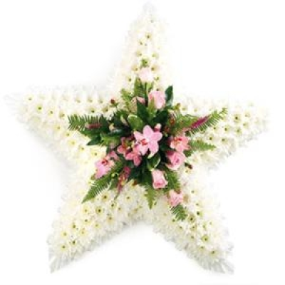 Star - This massed star shaped tribute is subtle yet striking set off with a lovely pink spray in the centre.