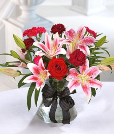 Kisses - Striking pink Lilies, mixed with deep red Roses and Carnations. A generous bouquet for romantic day to show your love. Hand-Tie in water.