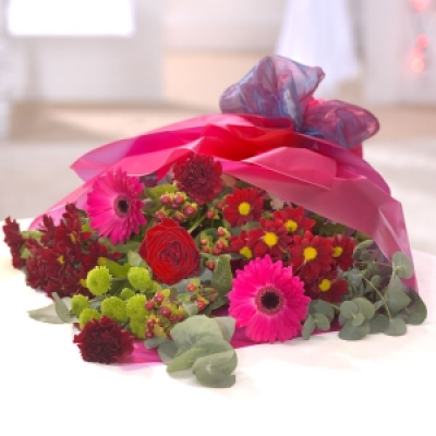 Warm Hearted - Romantic reds and burgundy are incorporated into this romantic bouquet including a red Rose, Gerberas, Carnations and Chrysanthemums.