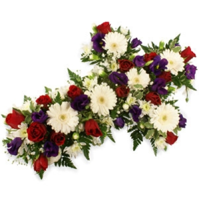 Loose Mixed Cross - A pretty cross-shaped sympathy tribute in shades of red and purple, featuring gerberas and veronica amongst an array of lush foliage. Edged in red ribbon and finished with bear grass, this is a popular traditional funeral tribute suitable for many situations. Price: Small 2ft £55. 00 Standard 3ft £75. 00, Luxury 4ft £100. 00, Superior 5ft £150. 00, Extra Superior 6ft £180. 00 Medium size displayed 100cm (3ft).