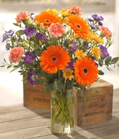 Summer Carousel - A summer carousel of colour. This bouquet is designed for someone who loves to arrange their own flowers. The feature flowers are Gerbera and Carnations accompanied by Lisianthus, Chrysanthemum and September flowers. Hand-Tie in water.