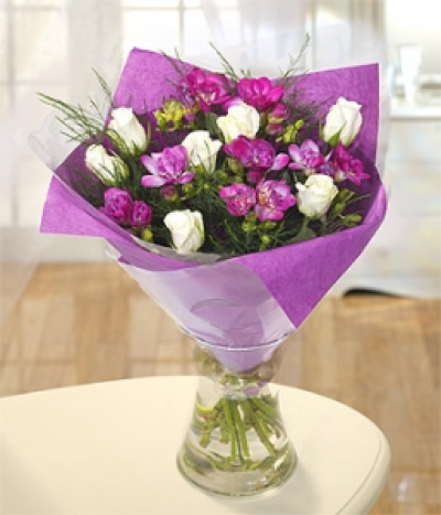 Moonlight - A sumptuous mix of luxurious purple Freesias and white Roses, complimented perfectly with tree ferns. An enchanting bouquet. Hand-Tie in water.