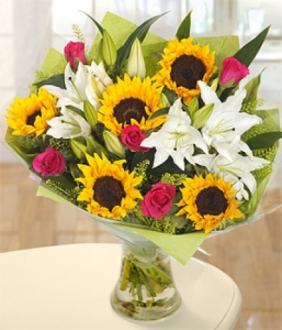 Sunflower Mix - A bright and sunny arrangement of Sunflowers, Oriental Lilies, cerise Roses and green Bell flowers. An absolutely stunning and fabulously fragrant bouquet.
