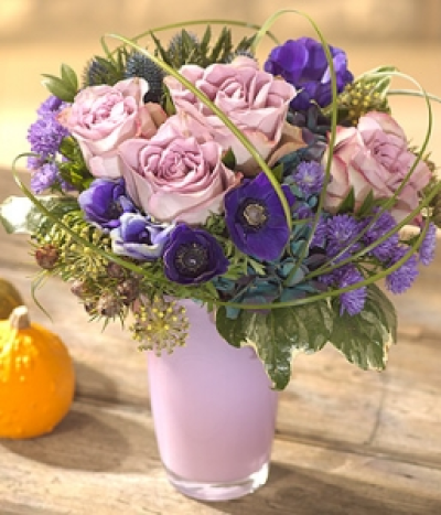 Rhapsody in Blue - A simply enchanting flower arrangement in rich royal blues and delicate lavender shades. Roses, Hydrangea, Aster, Anemone, Myrtle, Leucadendron and Eryngium are perfectly presented in a lilac glass vase.