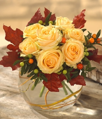 Symphony - A beautiful golden and deep red colour combination in a magnificent glass ball vase. Roses, Solanumn, twisted Willow twigs and red dyed Oak leaves combine to form this simply stunning flower arrangement.