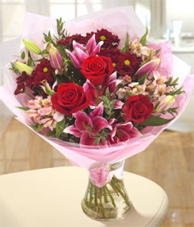 Passion For Luv - A rich, luscious bouquet of deep red Chrysanthemum blooms and velvetly red Roses, neatly nestled along side beautiful Cobra Lilies.