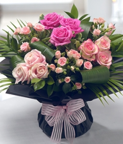 Venice - Elegant and stunning in design, this Rose bouquet features striking Palm and Aspidistra leaves.