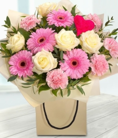 Captivated - A delightfully delicate pink and white romantic gift bag Bouquet featuring white Roses, pink Gerberas and Carnations.