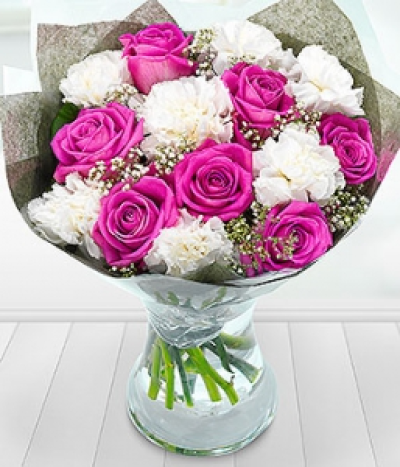 Pink Blessings - The white Carnations have been nestled in amongst pretty pink Roses with a touch of Gypsophilia to create this delightfully delicate bouquet.