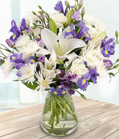 Hopelessly Devoted - An incredibly beautiful bouquet of white Lilies, Spray Chrysanthemums and Carnations mixed with blue Irises and lilac Lisianthuses.