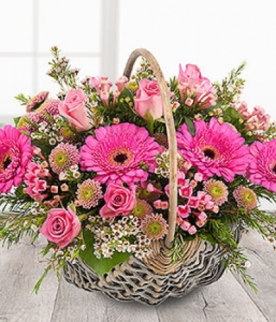 Secret Garden - A pretty pink flower basket featuring aqua Roses, Spray Chrysanthemums, Bouvardia and cerise Germinis coupled with delicate cream Wax Flowers.