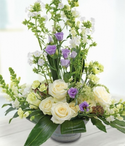 Serenity - The lilac Lisianthus at the centre of this exquisite arrangement sit perfectly alongside the pure white Roses, Antirrhinums, Phlox, Ammi and Spray Carnations. An eye catching and aromatic display.