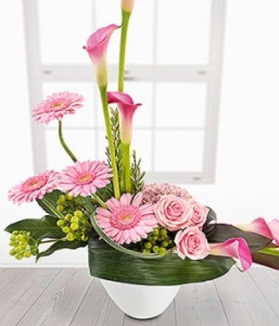Ensemble - Make a statement with this incredible pink Calla Lily, Germini, Rose and Hydrangea container arrangement. Green Hypericum Berries, a touch of Rosemary and a flourish of foliage complete the piece to perfection.