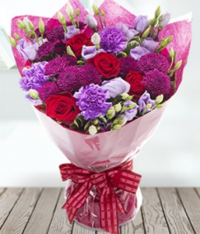 Embrace - A mixed aquapack deep red roses, rich red chrysanthemums complement the lilac carnations and lisianthus.