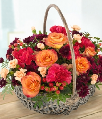 Seasonal Basket - Orange Roses married with orange and cerise Carnations and deep burgundy Spray Chrysanthemums with a generous dash of pretty Hypericum Berries. A simply stunning autumnal flower basket.