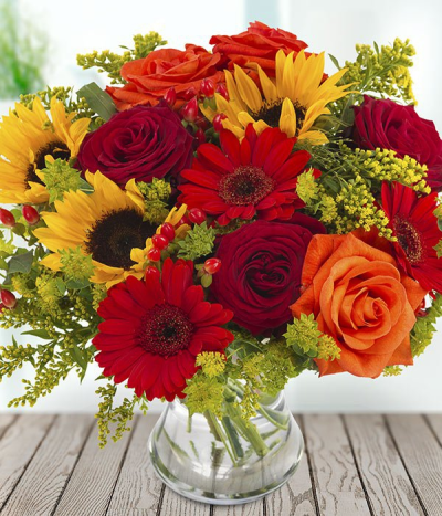 Shades of Summer - A stunning aqua pack hand tied bouquet in shades of red, orange and yellow. Crafted with sunflower, hypericum, rose, solidago and bulpeurum.