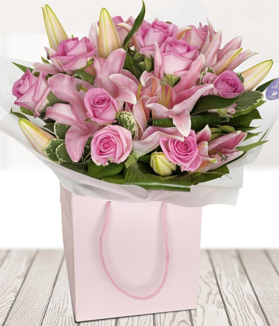 The Classic - A hand-tied explosion of the roses and lilies. A classic design for any occasion.