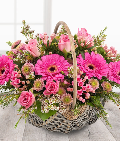 Soft touch - A pretty pink flower basket featuring aqua Roses, Spray Chrysanthemums, Bouvardia and cerise Germinis coupled with delicate cream Wax Flowers.