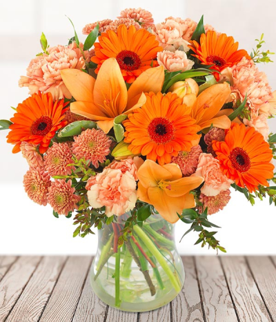 Peach Glow - Peach & orange tones are the focal point of this pretty bouquet, it is arranged beautifully to show off the perfect combination of lilies, carnations, germini and chrysanthemums.