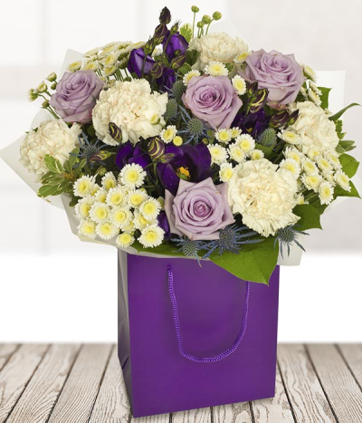 Lilac Rose Bouquet - A beautiful hand-tied bouquet of Lilac, purple and white flowers. The Lilac roses in the middle of the bouquet is surrounded by other complimentary flowers in similar soft pastel tones.