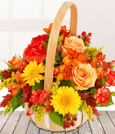 Lovely Sunny Day - This rustic arrangement of autumn stems is perfectly presented in a wicker basket. Featuring peach roses, yellow germini, alstroemeria, hypericum and array of autumn foliages.