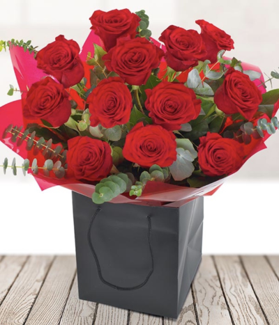Twelve Red Roses - One dozen of the most luxurious red roses. The luscious deep red colour of the roses is complemented perfectly with an array of gypsophila and seasonal foliage. A dozen red roses says more than 'I Love You', it says 'Be Mine Forever?'. A perfect romantic gesture.